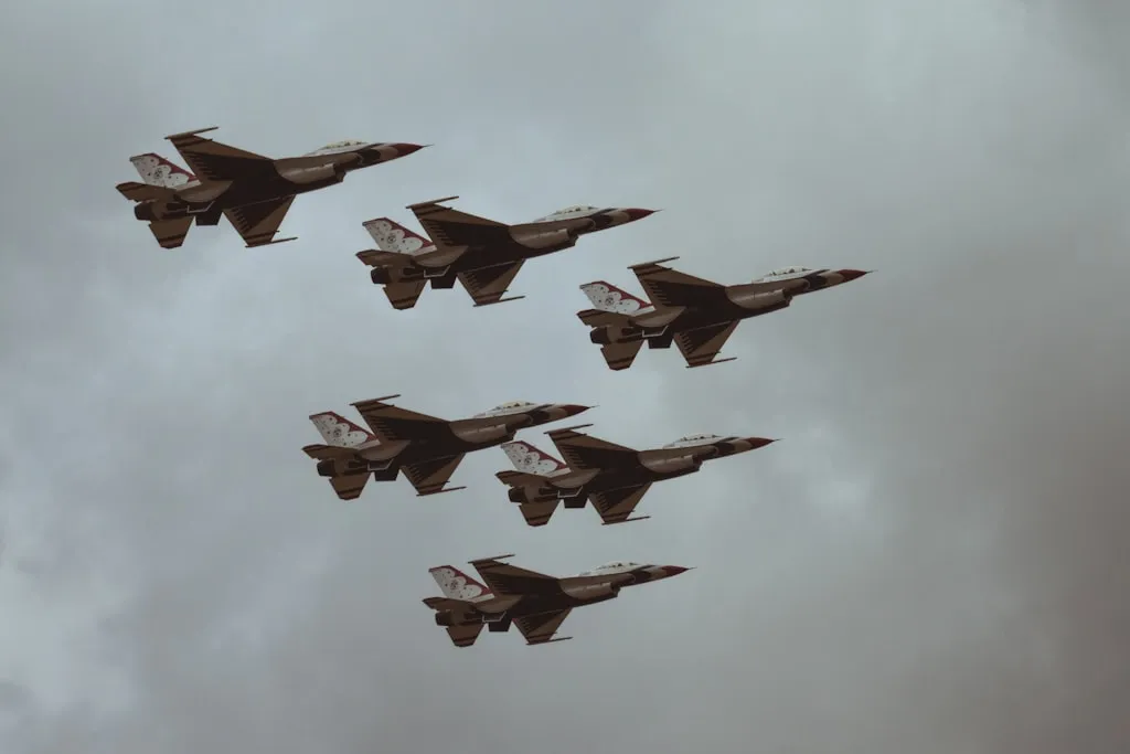 青空を背景に編隊飛行する6機の戦闘機のシルエット